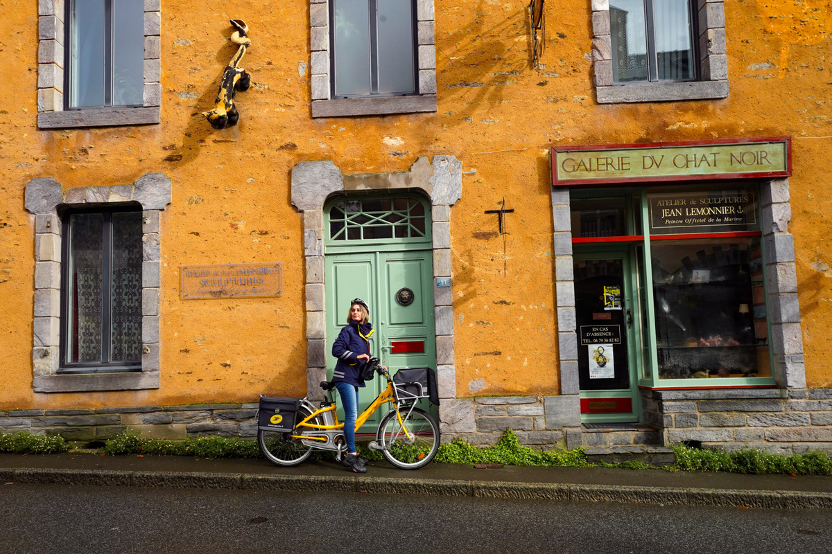Image d'illustration d'une factrice sur son vélo